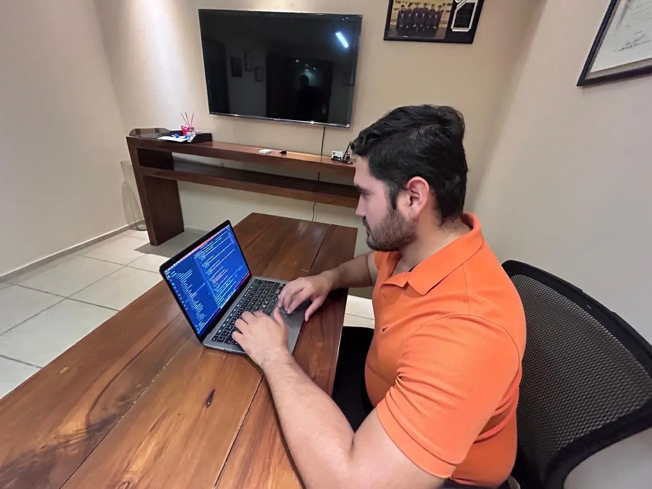 Antonio programando en su laptop en una sala de juntas